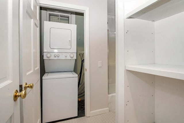 laundry area with stacked washer and clothes dryer and light tile patterned floors