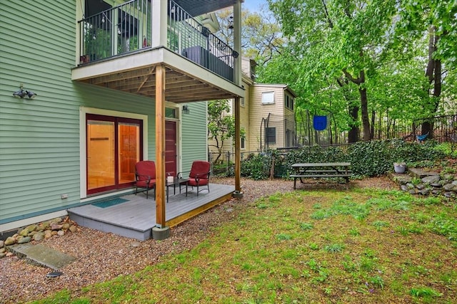 back of property featuring a balcony, fence, and a deck