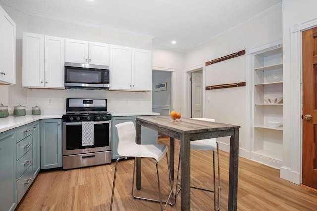 kitchen with appliances with stainless steel finishes, light wood finished floors, white cabinetry, light countertops, and recessed lighting
