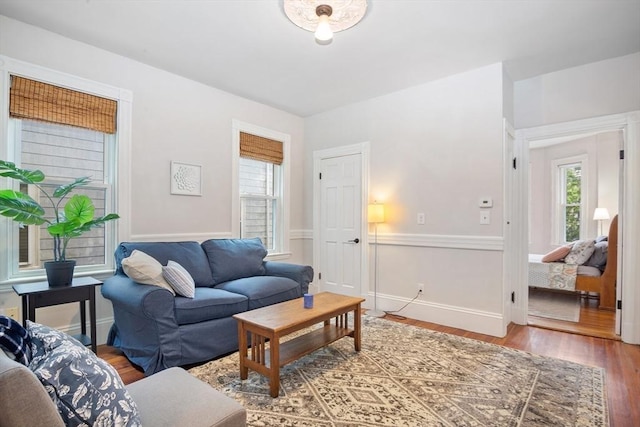 living area with plenty of natural light, wood finished floors, and baseboards
