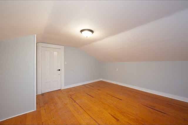 additional living space featuring hardwood / wood-style floors and vaulted ceiling