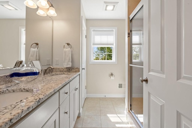 bathroom with a sink, tile patterned flooring, double vanity, and a stall shower
