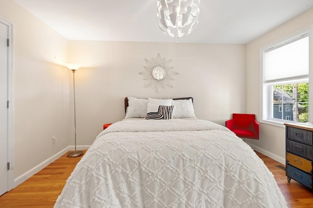 bedroom with light wood finished floors and baseboards