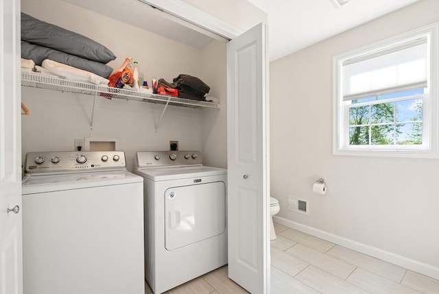laundry room featuring washing machine and clothes dryer, laundry area, baseboards, and visible vents