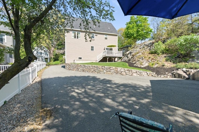 back of property with a wooden deck and fence