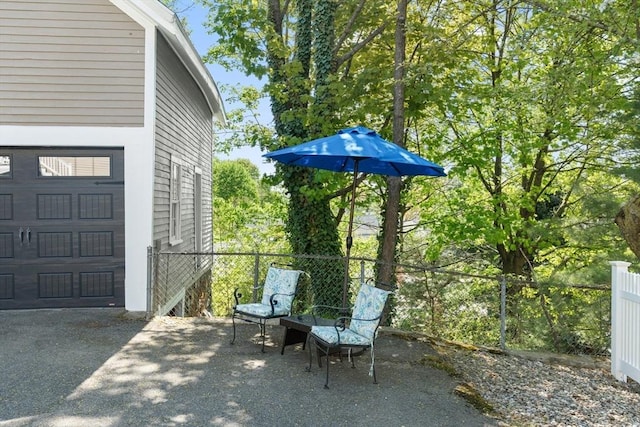 view of patio / terrace with a garage and fence