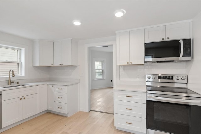 71 Water St, Quincy, MA 02169 - kitchen featuring appliances with stainless steel finishes, a sink, light countertops, backsplash, and recessed lighting