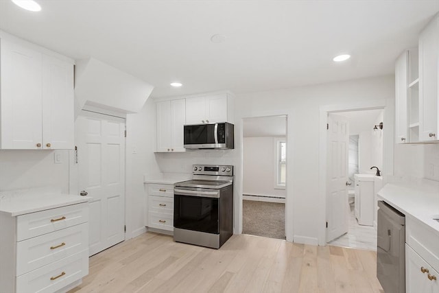 71 Water St, Quincy, MA 02169 - kitchen with appliances with stainless steel finishes, light wood-style floors, white cabinets, a baseboard heating unit, and light countertops