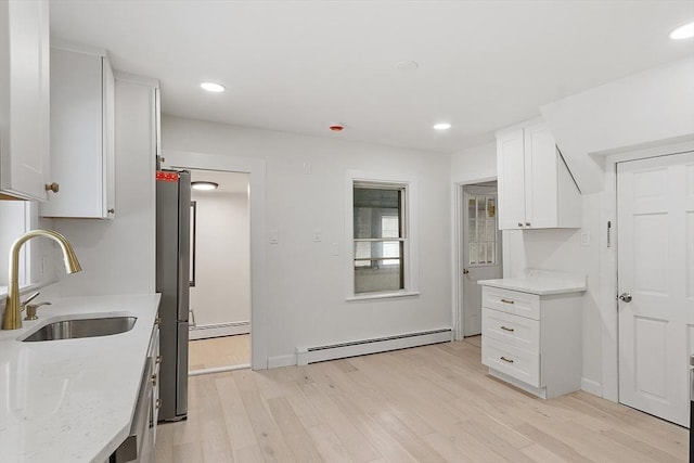 71 Water St, Quincy, MA 02169 - kitchen with a baseboard heating unit, a sink, freestanding refrigerator, light wood finished floors, and white cabinets