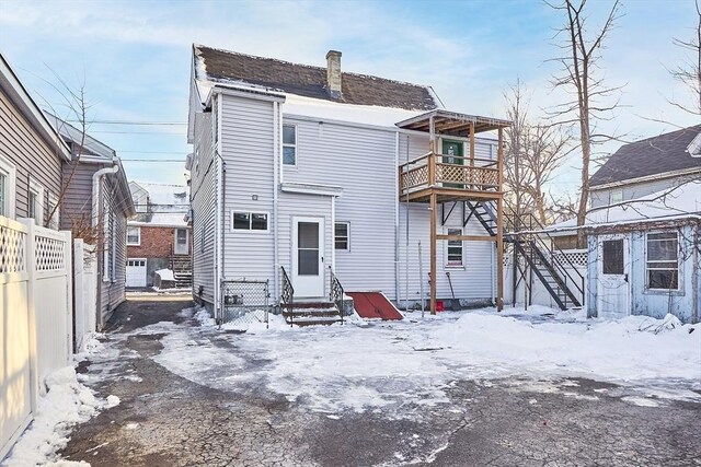 71 Water St, Quincy, MA 02169 - snow covered property with a balcony, entry steps, fence, and a chimney