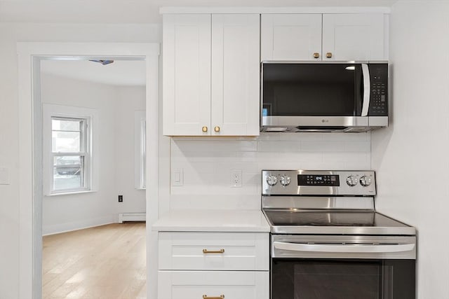 71 Water St, Quincy, MA 02169 - kitchen featuring appliances with stainless steel finishes, light wood-type flooring, white cabinets, light countertops, and baseboards