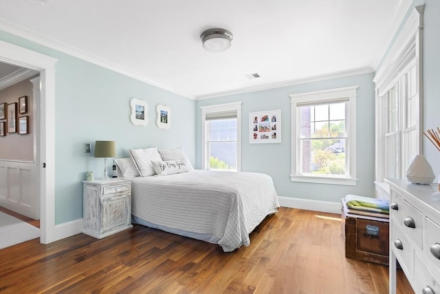 bedroom with crown molding, dark wood finished floors, and baseboards