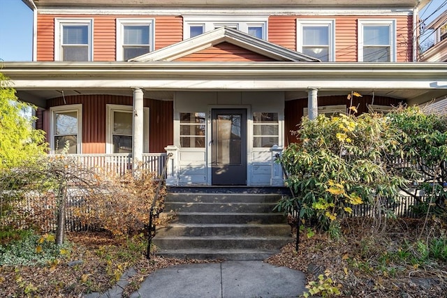 view of exterior entry featuring covered porch