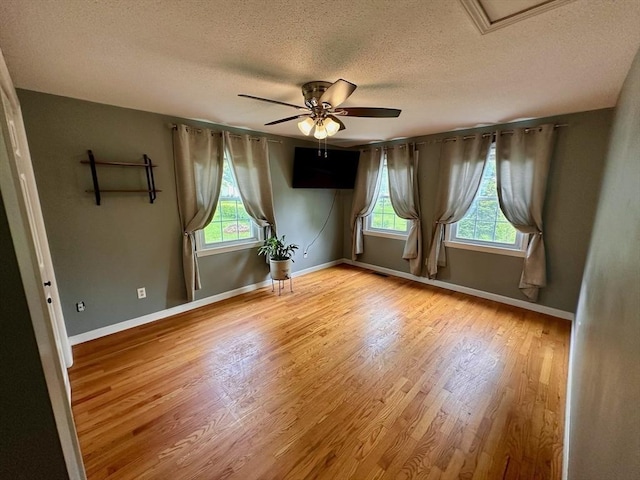 17 Walnut St, Gill, MA 01354 - empty room featuring a textured ceiling, plenty of natural light, wood finished floors, and ceiling fan