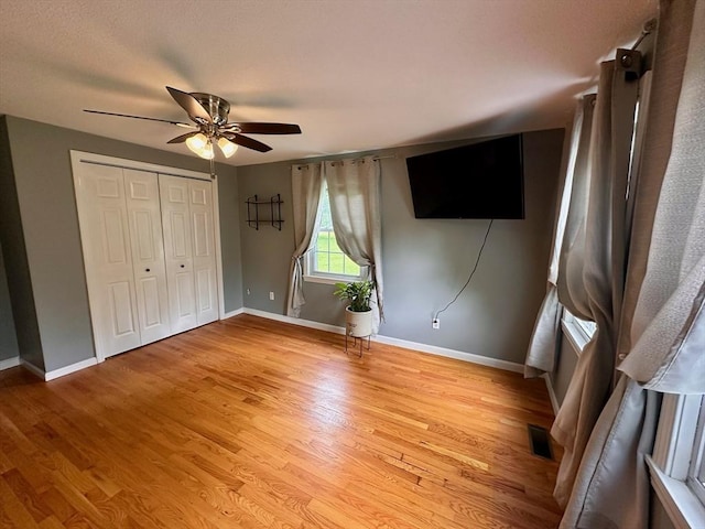17 Walnut St, Gill, MA 01354 - unfurnished bedroom featuring baseboards, light wood-style floors, ceiling fan, and a closet