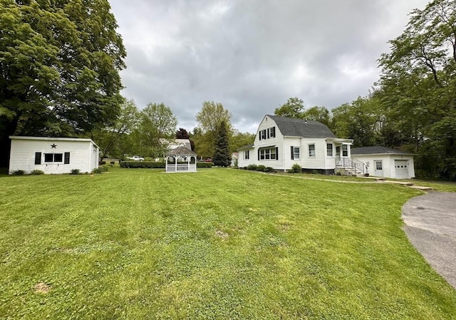 17 Walnut St, Gill, MA 01354 - view of grassy yard featuring a gazebo, an outdoor structure, driveway, a garage, and view of wooded area
