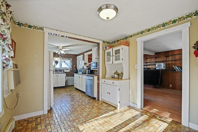 kitchen with radiator heating unit, ceiling fan, white cabinets, cooling unit, and stainless steel appliances