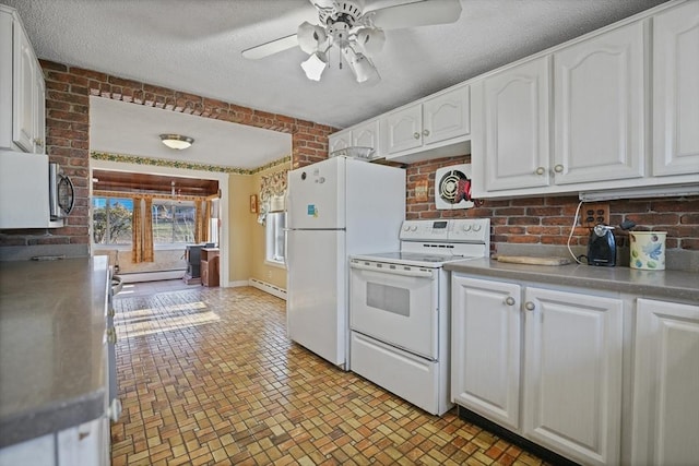 kitchen with white appliances, white cabinetry, brick wall, and a baseboard heating unit