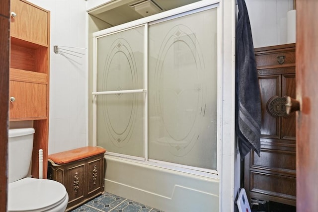 bathroom with tile patterned floors, bath / shower combo with glass door, and toilet