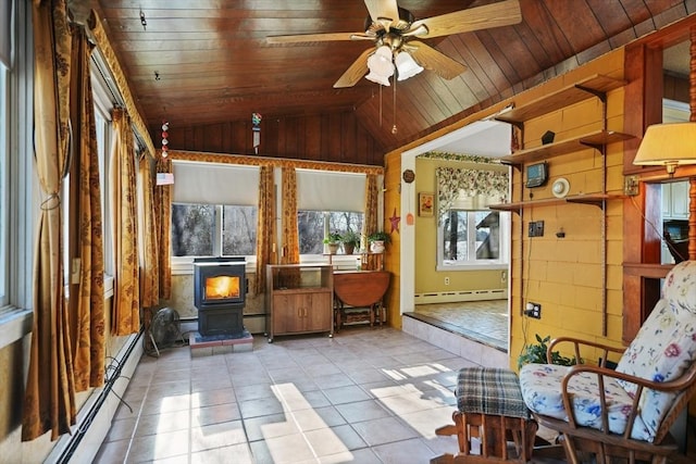 unfurnished sunroom featuring wood ceiling, baseboard heating, a wood stove, ceiling fan, and lofted ceiling