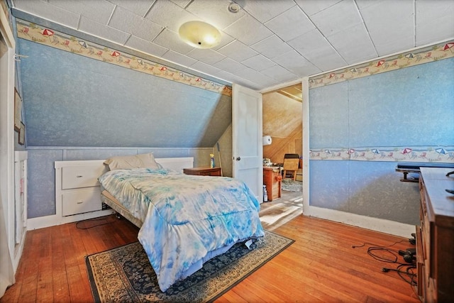 bedroom with hardwood / wood-style floors and lofted ceiling