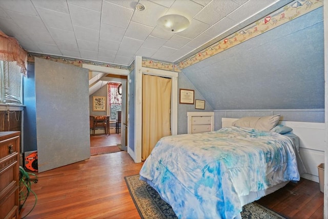 bedroom with wood-type flooring and lofted ceiling