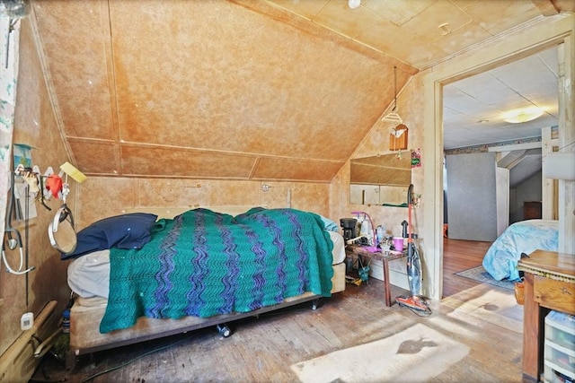 unfurnished bedroom featuring hardwood / wood-style flooring and vaulted ceiling