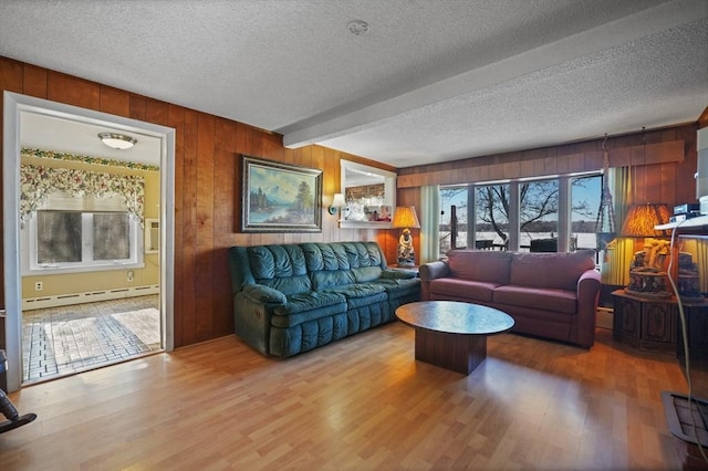 living room featuring beam ceiling, wooden walls, a baseboard radiator, and a textured ceiling