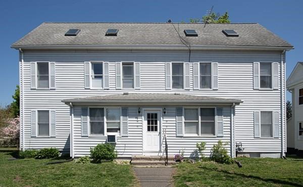 townhome / multi-family property with a front yard and entry steps