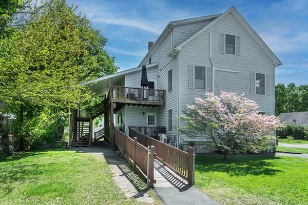 view of side of home with stairs and a wooden deck