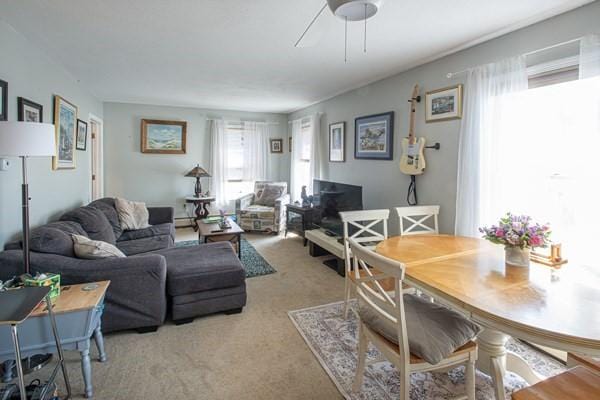 living room featuring light carpet and a ceiling fan