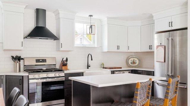108 Central St, Ipswich, MA 01938 - kitchen with wall chimney exhaust hood, stainless steel appliances, a kitchen breakfast bar, light countertops, and backsplash