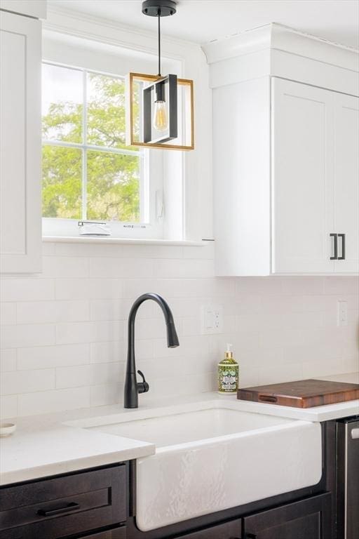 108 Central St, Ipswich, MA 01938 - kitchen view of decorative backsplash, white cabinets, light countertops, decorative light fixtures, and dark brown cabinetry