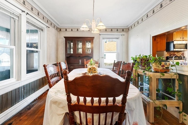 dining area with dark hardwood / wood-style floors, ornamental molding, and a notable chandelier