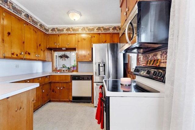 kitchen with appliances with stainless steel finishes, sink, and crown molding