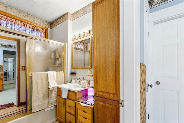 bathroom featuring vanity and shower / bath combination with glass door