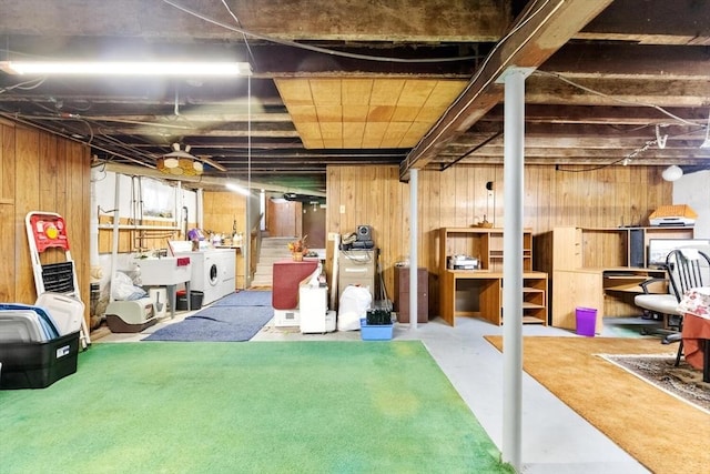 basement with washer and dryer and wood walls