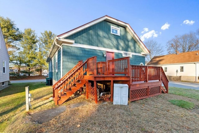 rear view of house with a deck and a yard