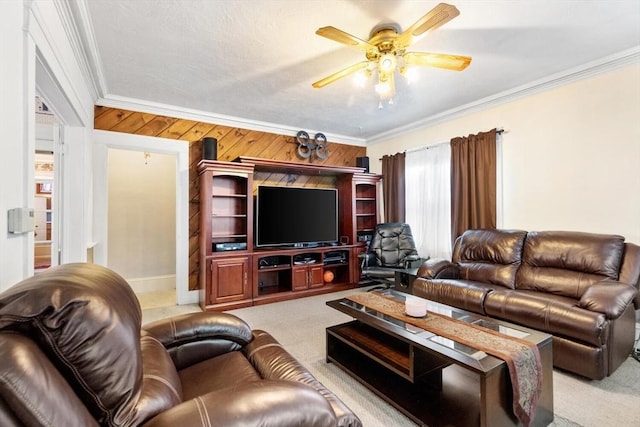 carpeted living room featuring ceiling fan, crown molding, and wood walls