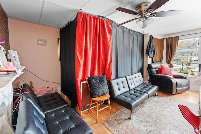 living area with wood finished floors and a ceiling fan