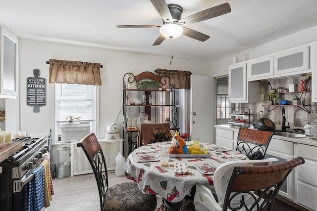 dining room featuring light hardwood / wood-style floors, ceiling fan, and sink