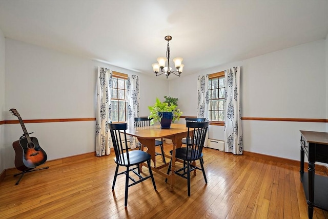 dining area with a healthy amount of sunlight, baseboards, light wood-type flooring, and a chandelier