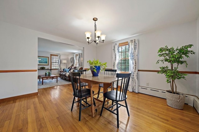 dining room featuring an inviting chandelier, light wood-style floors, and a healthy amount of sunlight