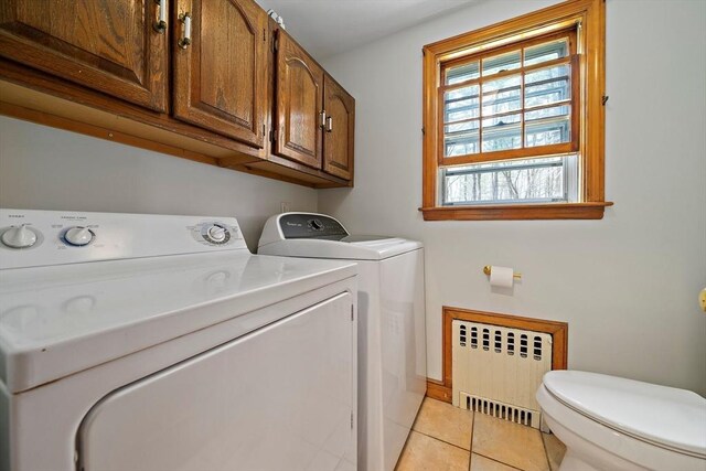 laundry area with light tile patterned floors, radiator, laundry area, and washing machine and clothes dryer