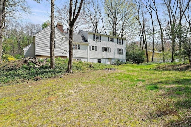 back of property featuring a yard and a chimney