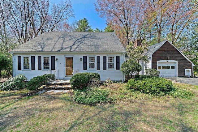 view of front facade featuring a chimney, a front lawn, and a garage