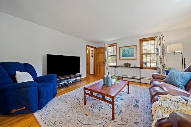 living area with baseboard heating and wood finished floors