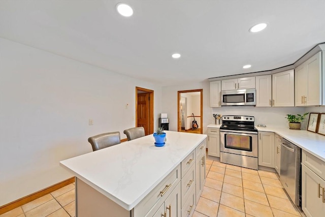 kitchen featuring recessed lighting, light countertops, appliances with stainless steel finishes, and light tile patterned floors