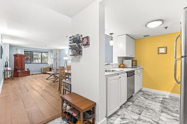 15 N Beacon Unit Ul01, Boston, MA 02134 - kitchen with appliances with stainless steel finishes, light countertops, white cabinets, and decorative backsplash
