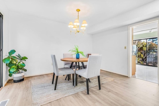 dining area featuring light hardwood / wood-style floors and an inviting chandelier